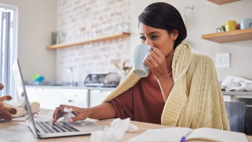 women drinking a coffee while working and sick