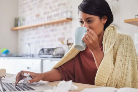 women drinking a coffee while working and sick